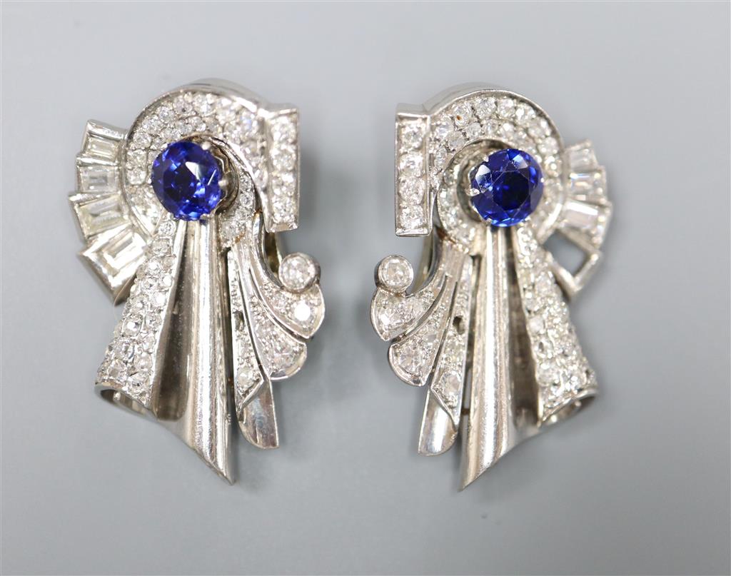 A pair of diamond and synthetic? sapphire clips in white metal settings (tests as platinum), white metal fitments